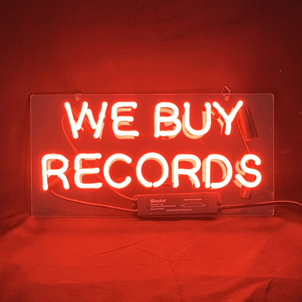 Illuminated 'We Buy Records' neon light sign hanging indoors