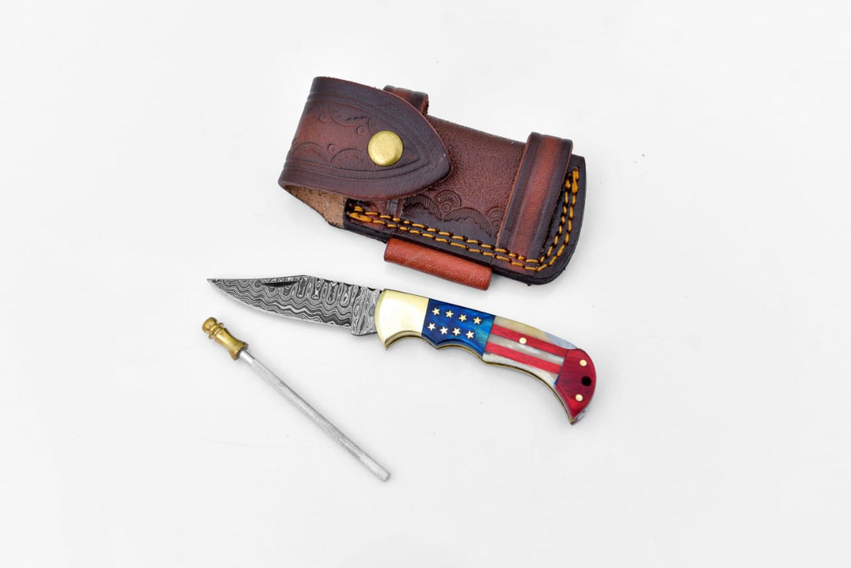 Damascus steel pocket knife Limited Run Titan Patriot TF-055 showing folded blade with hand-carved spine and engraved bolster in a leather sheath