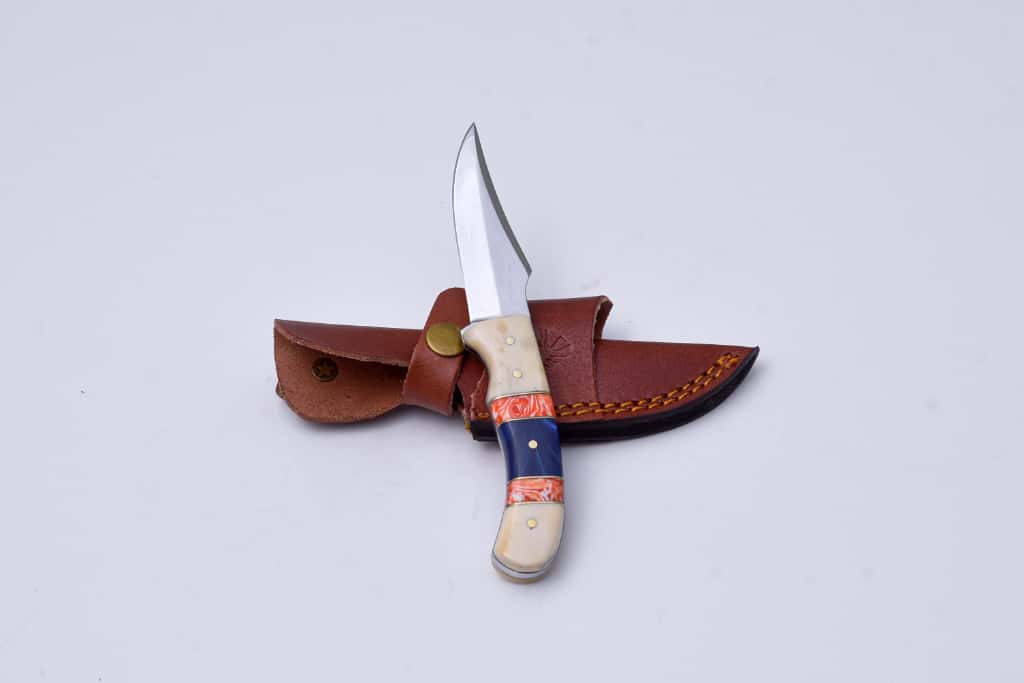 Handcrafted Fixed Blade Hunting Knife with custom bone, resin, and brass handle alongside a hand-stitched leather sheath