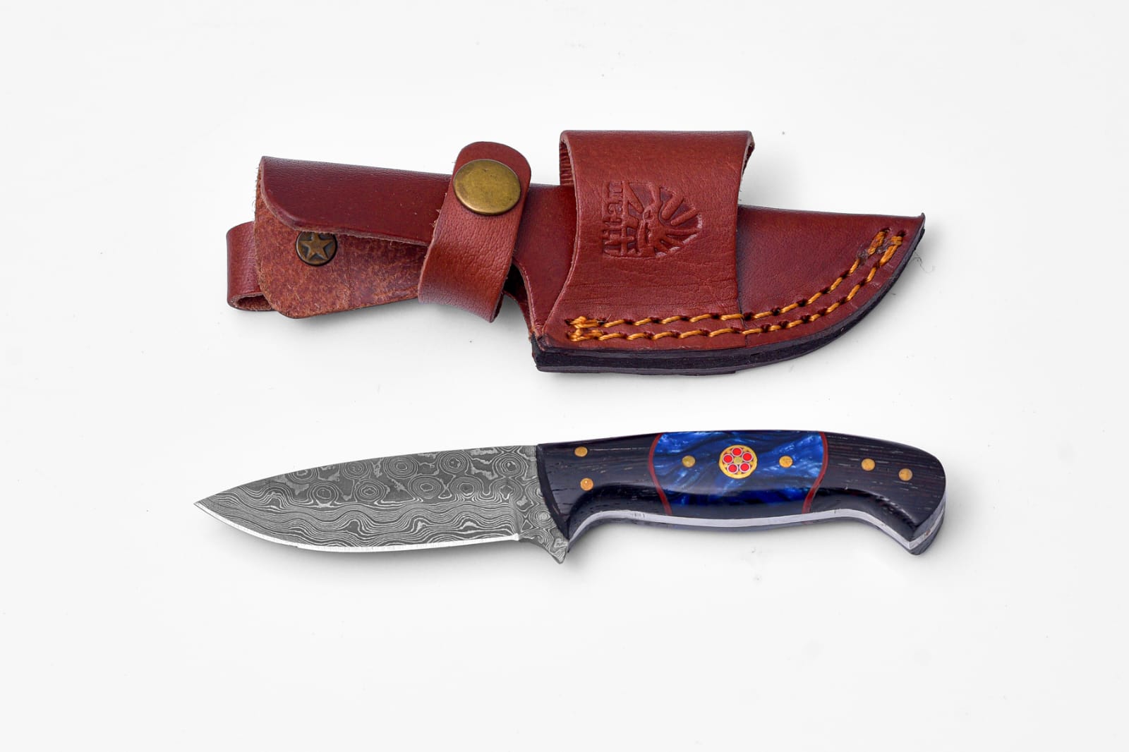 Handmade Damascus Steel Knife with Blue Resin & Wenge Wood Handle resting on a dark surface