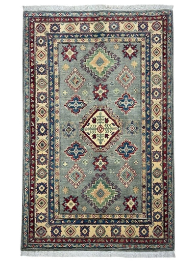 Hand-knotted Afghani Kazak wool rug in beige and red tones laid in a room