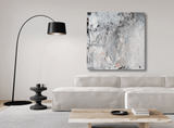Abstract gray, white, and black textured canvas print titled White Code hangs on a light beige wall above a cream sofa and a black arc floor lamp.
