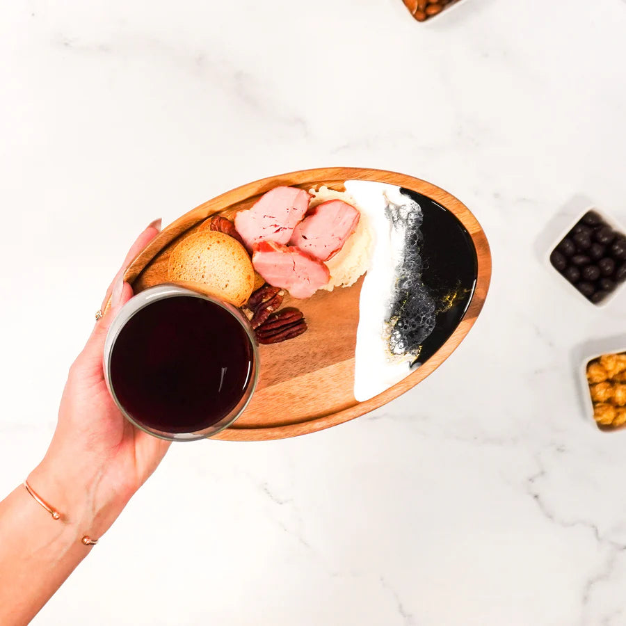 Hand holding a glass of red wine with a plate of dessert on a Wine & Appetizer Tray