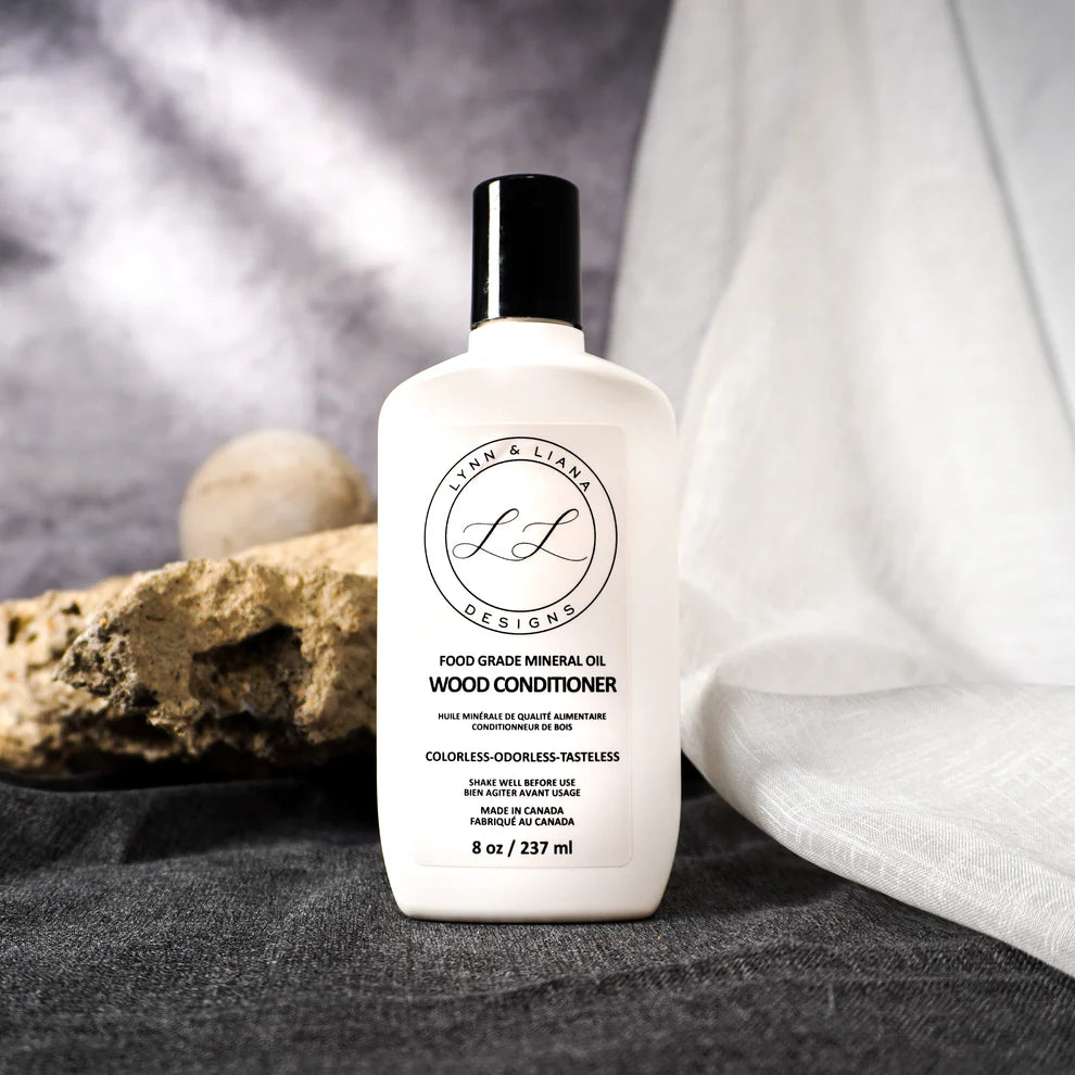 Bottle of wood conditioner with 'Lynn & Liana' branding on a textured surface.