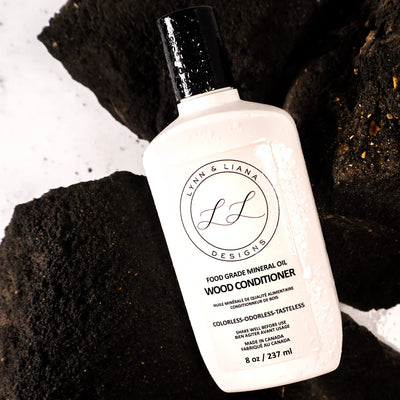 Bottle of wood conditioner with 'Lynn & Liana' branding on a textured surface.