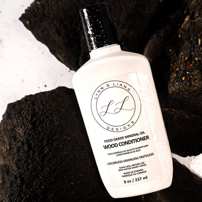 Bottle of Lyan & Liana Designs Wood Conditioner on a dark textured surface