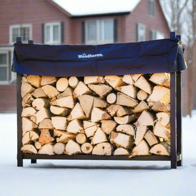 The Woodhaven 5 ft Firewood Rack in black showing stacked firewood on a patio