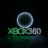 Neon sign displaying a white circle with a faint green Xbox logo inside and 'XBOX 360' text below, green on 'XBOX' and white on '360', against a black background.