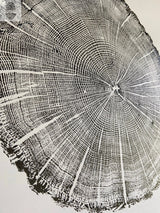 Black and white detailed close-up print of an oak tree cross-section showing growth rings and textured bark edges on a light background.