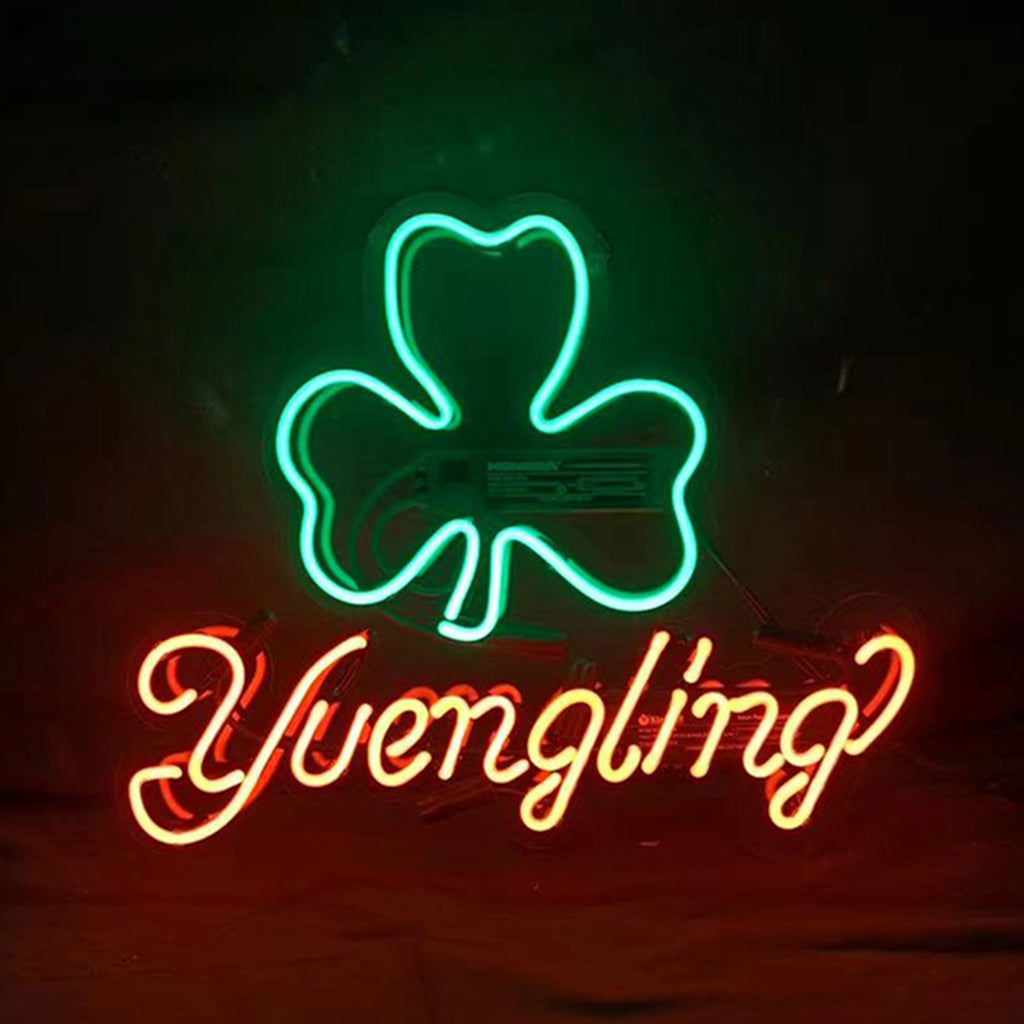 Green neon shamrock outline above red neon cursive 'Yuengling' text against a dark background.