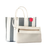 Striped woven tote bag in black and white with twisted rope handles and a red tag, shown with a beige zippered pouch featuring mesh and smooth textures.