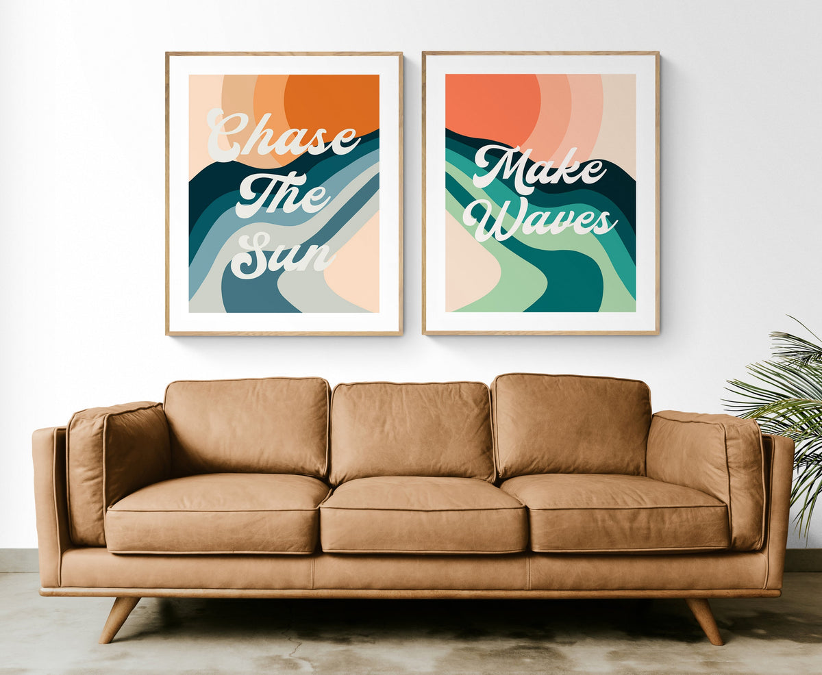 Two framed modern art prints above a brown leather sofa, featuring abstract wavy shapes in teal, peach, and orange with white text reading 'Chase The Sun' and 'Make Waves'.
