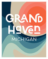 Abstract graphic print with layered waves in blue and beige tones below the text 'Grand Haven' in stylized white letters and 'Michigan' in clean white font.