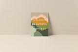Note card with abstract landscape in muted earth tones and text reading 'Collect Beautiful Moments' in white uppercase letters centered on cream background.