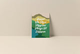Note card with layered abstract landscape in shades of green, teal, and mustard, featuring white script text reading 'Expect The Most Magical Things To Happen'.