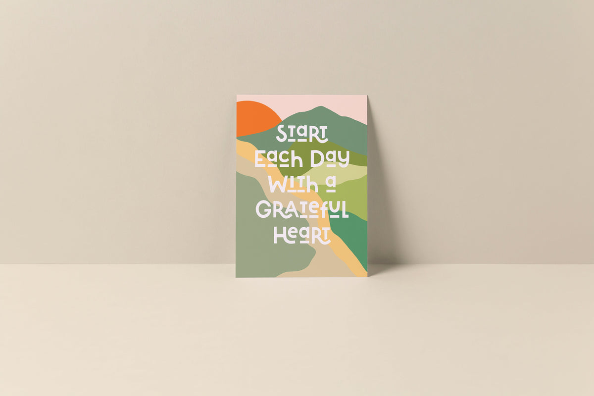 Note card with abstract shapes in green, orange, mustard, and cream colors, featuring white text that reads 'Start each day with a grateful heart' on a beige background.