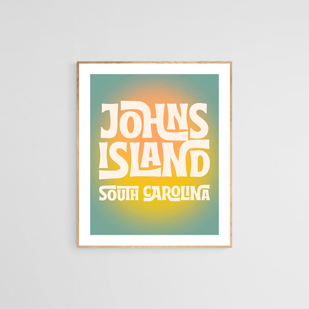 Framed modern art print with stylized text 'Johns Island South Carolina' in cream color on a gradient background blending teal, orange, and yellow hues.