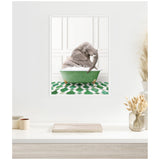 Framed artwork of a gray elephant sitting in a green clawfoot bathtub with white bubbles, against a white paneled wall and green patterned floor tiles.