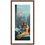A tiger with distinct black stripes rests on a teal-green couch inside a high-rise, with New York City skyscrapers and the Empire State Building visible through large windows.