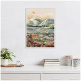 Framed canvas painting of a muted mountain landscape with a green lake and foreground floral area in soft reds and browns, hung on a plain white wall above a white desk.