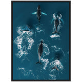 Aerial view of a school of six humpback whales swimming closely in deep blue ocean water, with white water trails showing their movement and wake.