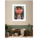 Framed portrait of a woman with dark hair adorned by pink flowers, wearing a lace blouse and large pink moths covering her eyes, hanging above a wooden bench with cushions.