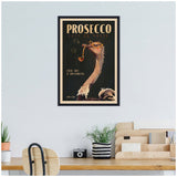 Framed vintage-style poster of an ostrich drinking prosecco with bubbles, on a black background with gold and beige text, hanging above a wooden desk.