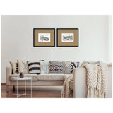 Two black-framed vintage postcard prints with brown mats, depicting Florence and Venice landmarks, hung above a beige couch with patterned cushions and a knit throw.