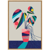 Abstract monstera plant with large, colorful geometric leaves in pink, blue, green, and yellow hues, set in a patterned pink vase on a navy blue surface.