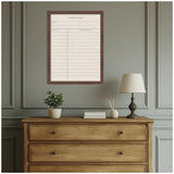 Framed linen fabric pinboard styled as a vintage library card with pale pink grid and wooden frame, hanging above a wooden dresser with lamp, books, and plant.