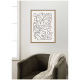 Framed abstract wall art with single black continuous line forming interlocking shapes on white background above dark gray velvet armchair with beige knit throw draped over arm
