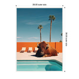 Large brown bison resting poolside on light beige deck with turquoise water, orange wall background, and two tall palm trees under a clear blue sky.