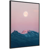 Framed canvas showing a large pastel pink full moon glowing above snow-capped Icelandic mountains with a soft pink sky background.