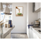 Bright kitchen with white cabinets, gray countertops, and a framed canvas of a mother and baby giraffe in a green bathtub on the wall.
