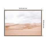 Framed canvas print showing a pale sand dune desert under a cloudy sky, with soft beige and light brown tones and smooth dune contours.