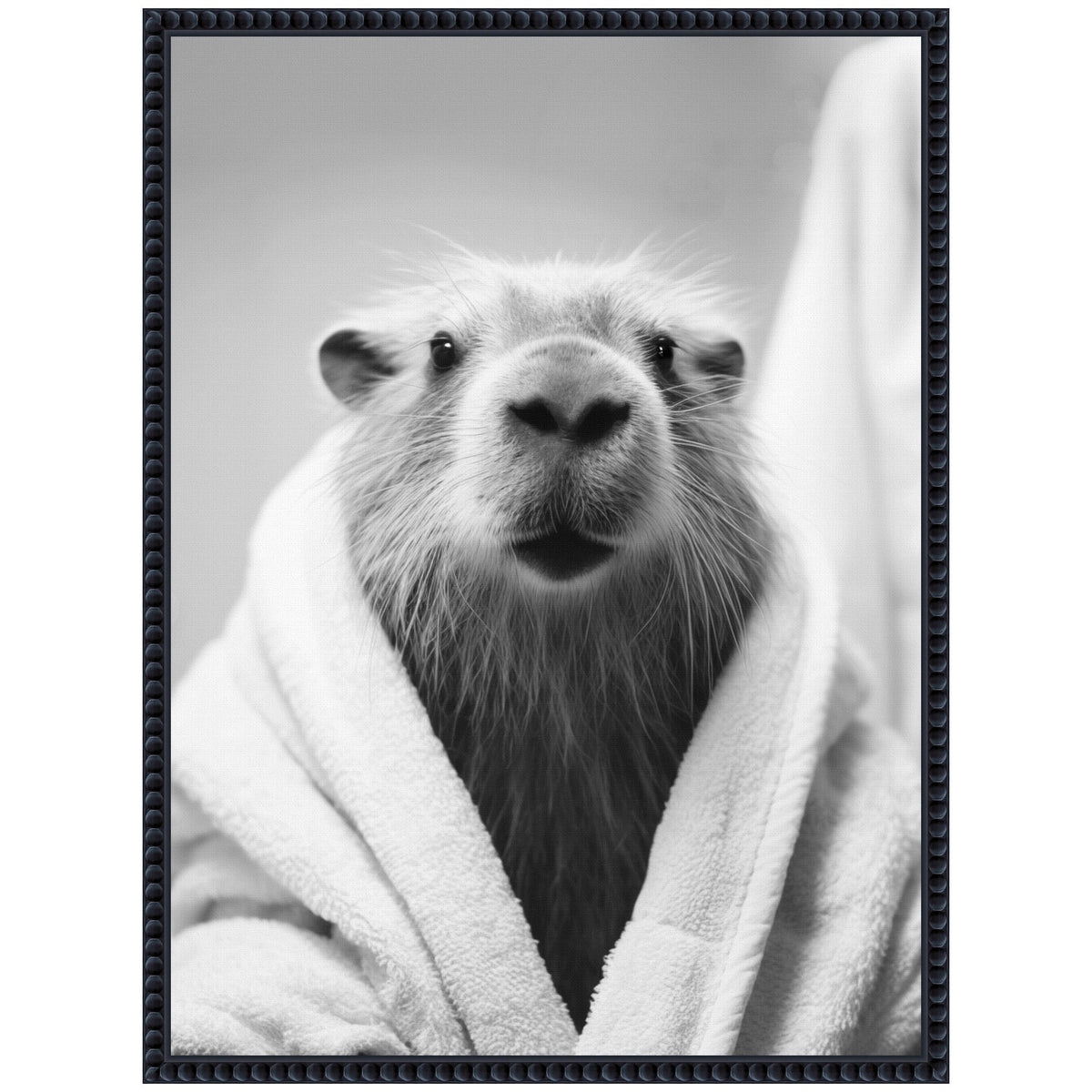 Close-up black and white photo of a capybara wrapped in a soft towel, with its head centered and fur slightly wet, framed in a textured dark border.