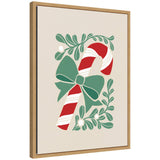 Framed canvas art showing a red and white candy cane with a green bow, surrounded by stylized green leaves and mistletoe berries