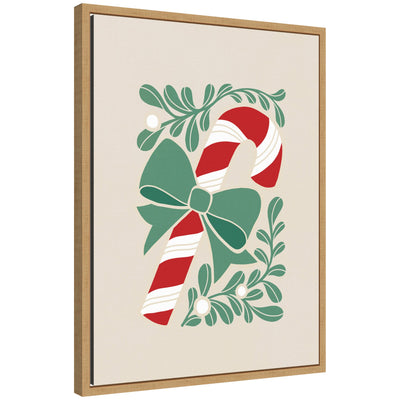 Framed canvas art showing a red and white candy cane with a green bow, surrounded by stylized green leaves and mistletoe berries