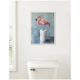 Framed painting of a pink flamingo standing on two stacked toilet paper rolls against a muted blue-gray background, hanging above a white toilet tank.