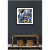 Abstract framed artwork by Leah Nadeau featuring geometric shapes in blue, white, gold, and red tones against a dark wall above a rustic wooden bench with two woven baskets underneath.