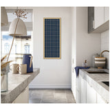Navy blue plaid framed fabric pinboard with thin white lines hanging vertically on a white kitchen wall between two concrete countertops.