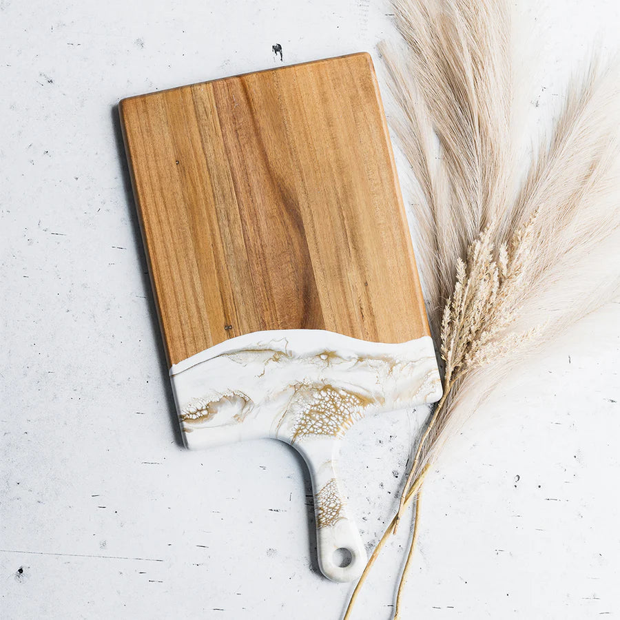 Wooden resin charcuterie board with white resin design on a light gray background