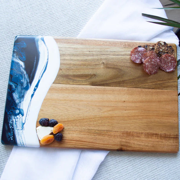 acacia resin serving bread board with a resin edge on a white surface, featuring small snacks.
