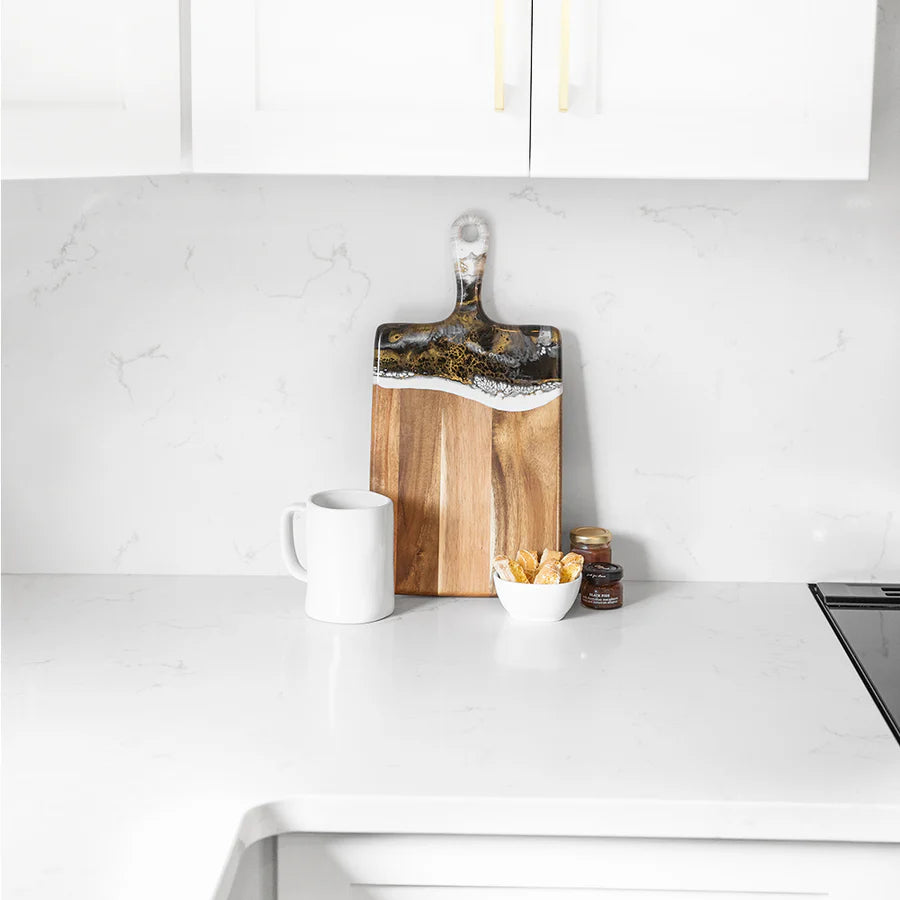 Wooden resin charcuterie board with a decorative edge on a kitchen counter.