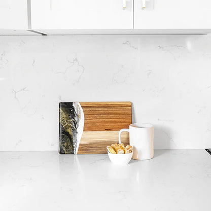 Wooden resin charcuterie board with a marble design on a white kitchen counter.