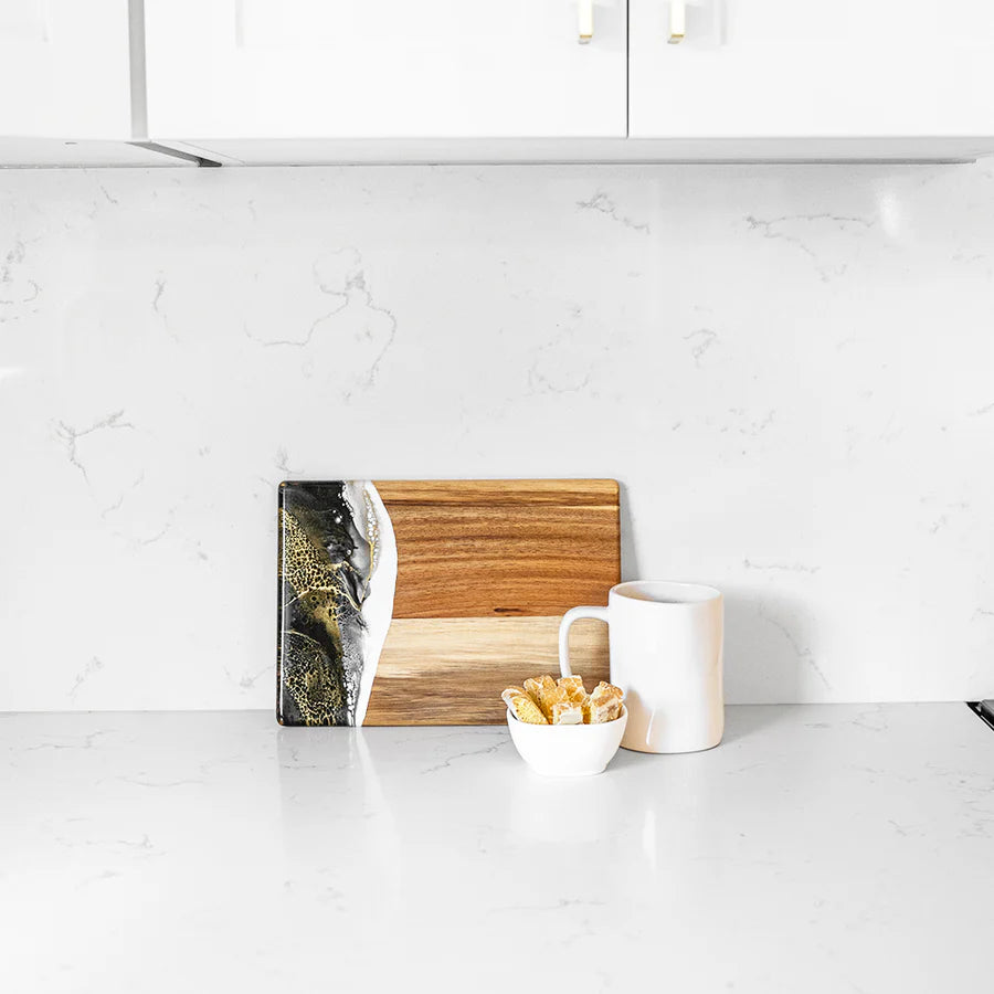 Wooden resin charcuterie board with a marble design on a white kitchen counter.
