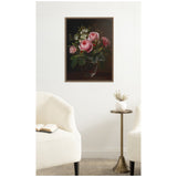 Framed canvas print of a dark-toned floral painting featuring pink roses and white anemones in a glass vase, displayed on a white wall between two white upholstered chairs.