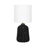 Table lamp with a black woven rattan base featuring a rounded, slightly tapered shape and a white cylindrical fabric lampshade.