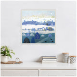 Framed canvas painting of a winter landscape with blue and white hues, featuring trees, hills, small houses, and a visible moon in the pale sky.