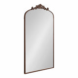 Tall, rectangular mirror with a rounded top arch and ornate dark bronze frame featuring intricate scrollwork at the crest.
